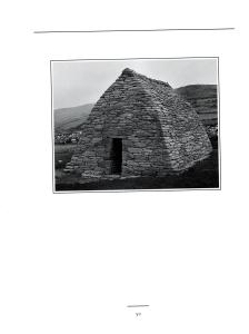 Black and white photograph of a triangle shaped hut made of stacked stone