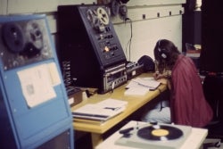 A student wearing headphones listens to a recording from a reel-to-reel-player in the Audio/Visual Department