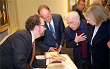 Director Martin Scorsese and President Jack DeGioia are shown a first edition of Endo's Silence by John Buchtel, Director of the Booth Family Center for Special Collections