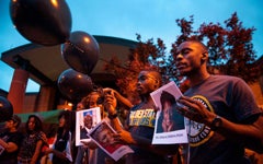 People holding black balloons and photographs at a prayer vigil for the nine victims of the Charleston shooting, from the African American Intellectual History Society.