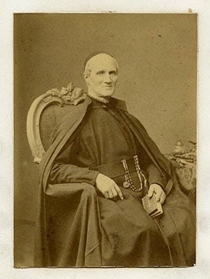 Peter Jan Beckx, wearing his cossack while seated, a small book in his left hand resting in his lap