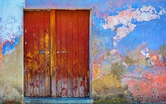 Red wooden door with faded paint.