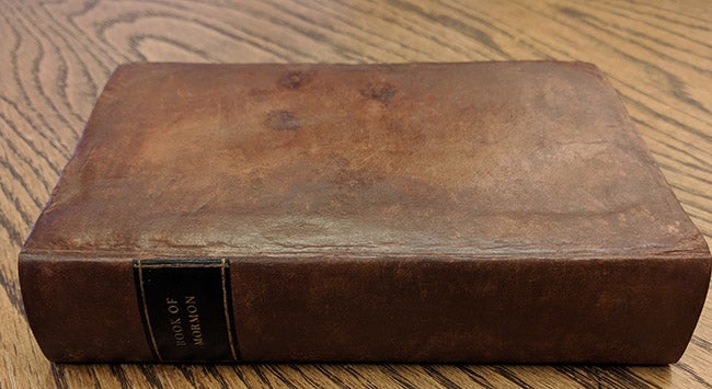 image of a repaired book lying flat on a table with the book spine facing the viewer