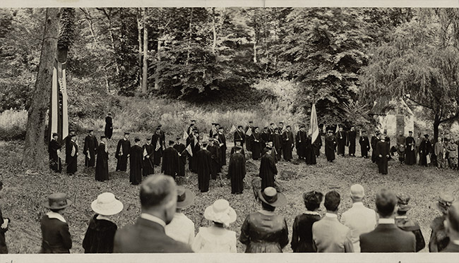 photograph of Georgetown faculty and students in regalia holding flags and banners after conservation treatment