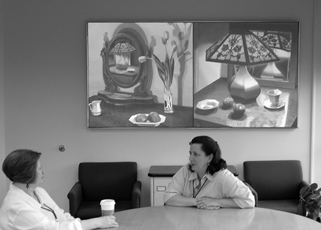 View inside the University Librarian's office: Executive Assistant Elaine Harris and Director of Development Aurilla Fusco discuss Library business under the Behnke painting, Victorian Still Life #3