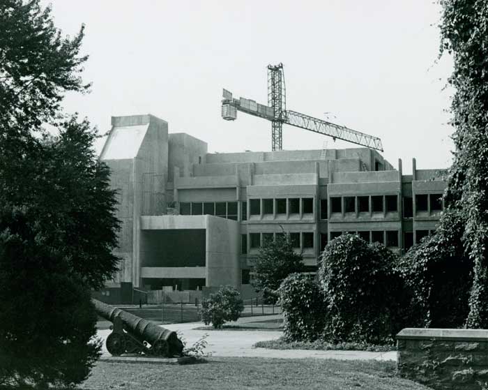 A construction crane rises behind Lauinger Library, which is almost complete except for the towers