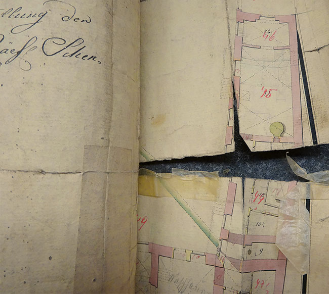 torn architectural drawing before conservation treatment