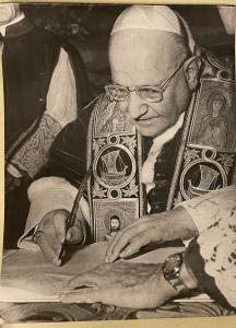 Pope John XXIII in papal regalia signing a document