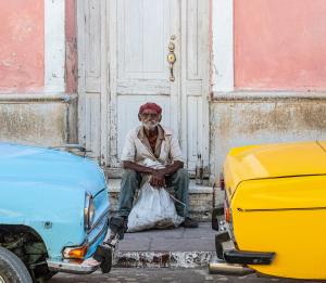 Color photograph of a man sitting in a street in Old Havana.