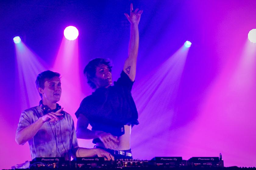 Two DJs performing at a concert.