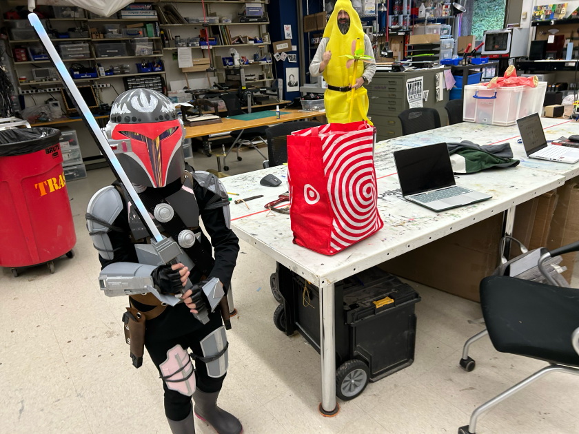a picture of the student's daughter wearing the full costume, posing with a mandalorian sword