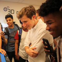 Group of students looking at a laser cutter