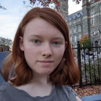 Chloe Anderson looks at the camera with Healy Hall in the background