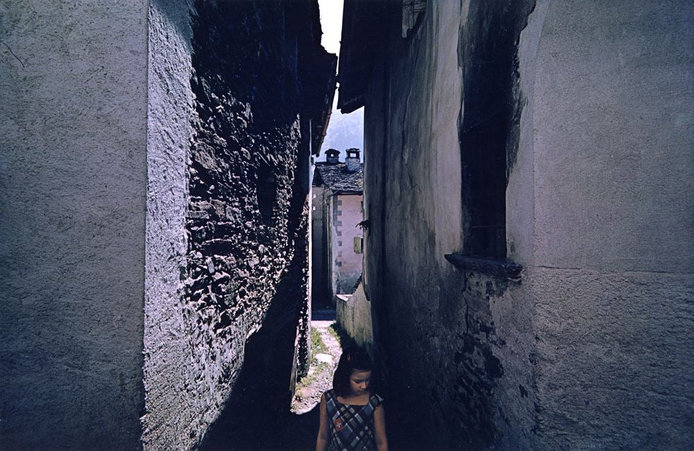 girl in narrow alley, standing looking downward