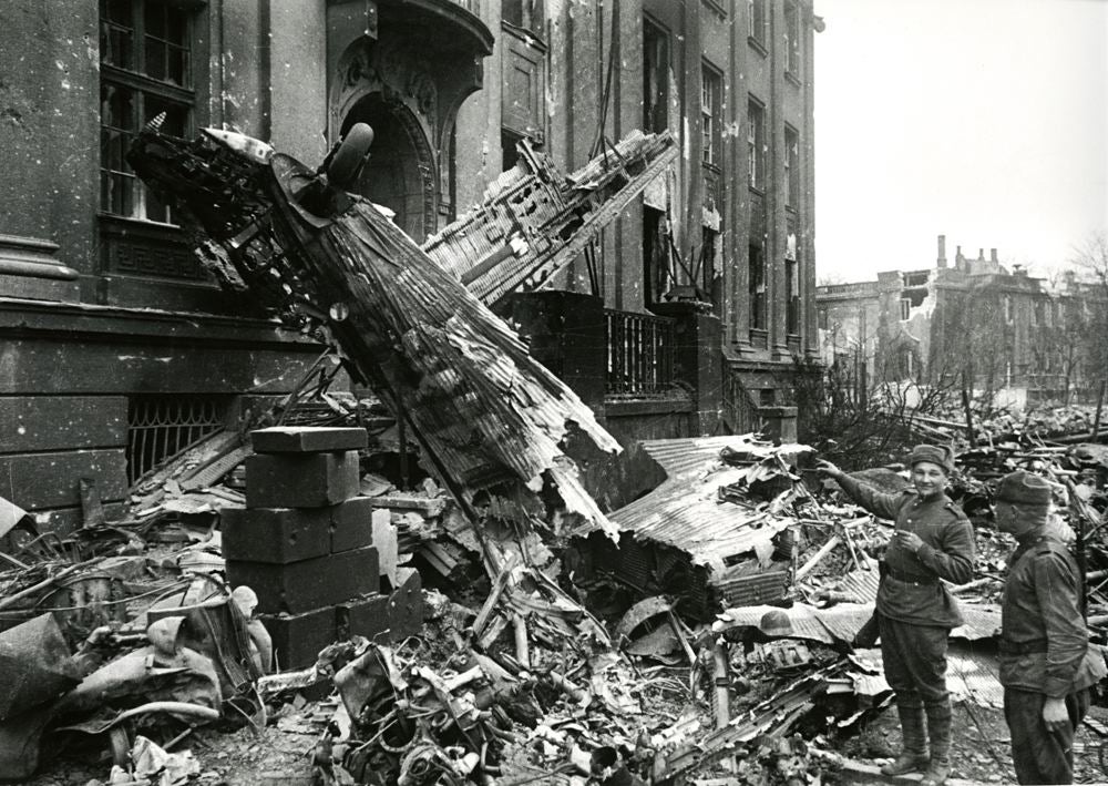 Two soldiers pointing at a downed plane