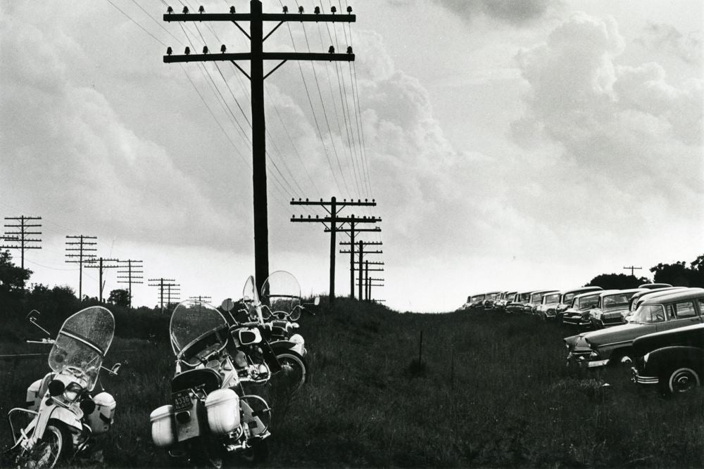 Motorcycles and cars underneath telephone wires
