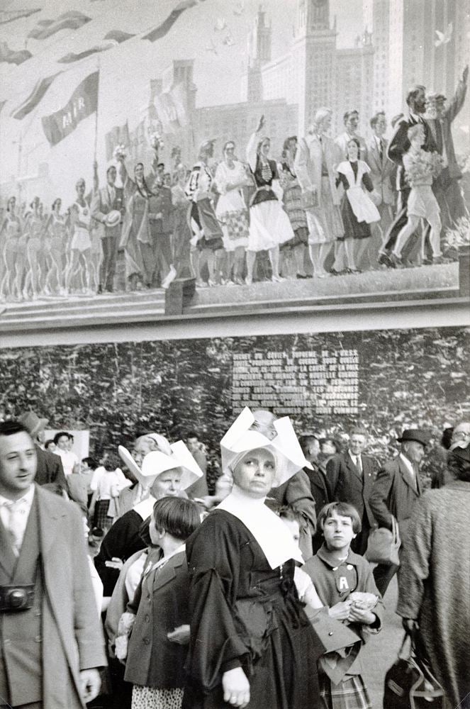Nun in crowd under mural