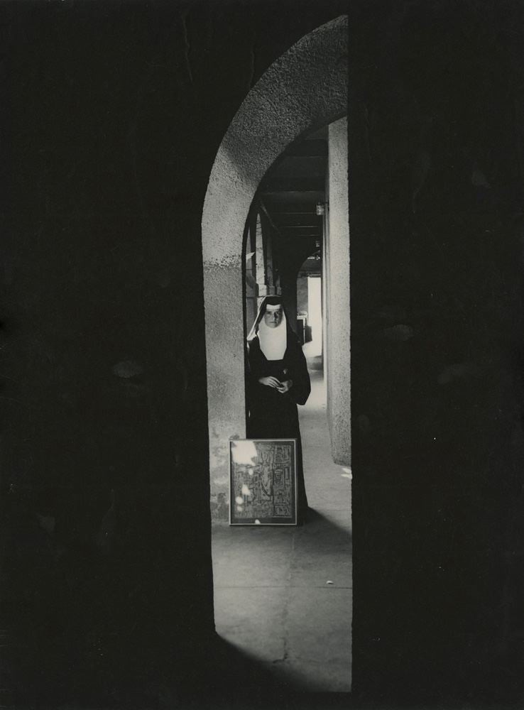 Nun in Courtyard holding artwork